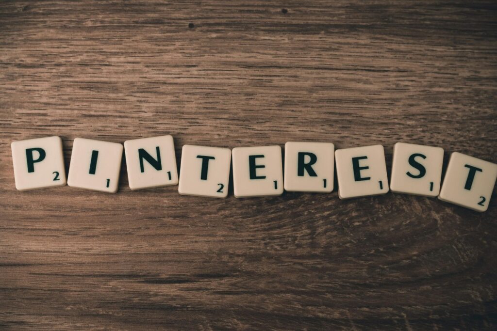 木质桌面上整齐排列着拼成“PINTEREST”的字母方块，每个方块带有数字标识。这一画面与“2025年美国Pinterest营销秘籍”相关，象征着Pinterest在2025年美国营销领域的重要角色和可探索的营销技巧 。
