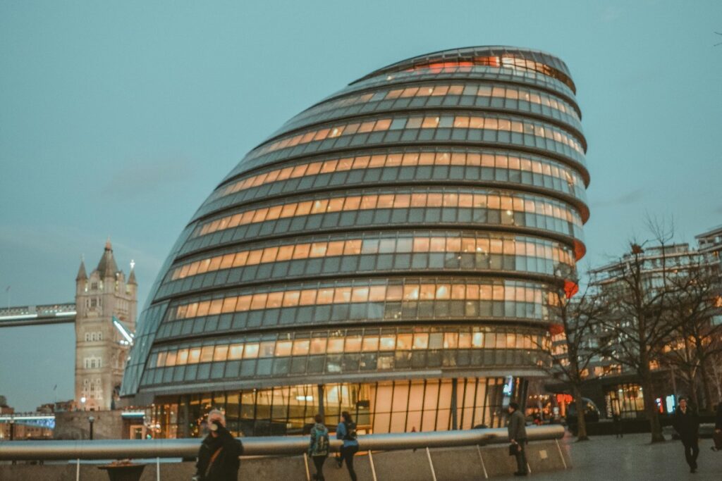 2025年英国Snapchat营销秘籍：夜幕降临，独特的伦敦市政厅如圆润的玻璃巨蛋，在灯光映照下散发温暖光晕。一旁古老的塔桥轮廓隐约，行人在周边漫步，新与旧在此和谐交融，尽显伦敦魅力 。