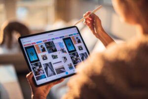 A person uses a tablet with a stylus, browsing through a visually - rich interface, possibly pondering over the topic "Douyin vs. Xiaohongshu: What's the Difference".