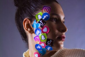 A side - profile view of a person with various social media icons like Instagram, TikTok, Facebook, etc., arranged on the face and neck area. This image is related to The Influencer Marketing Factory Creator Economy Report 2025, symbolizing the significant role of social media in the creator economy as described in the report.