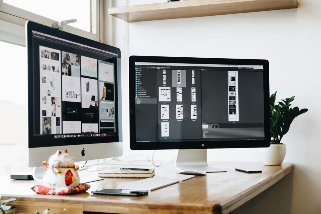Two computer monitors display content relevant to brand - related activities, perhaps hinting at the decision - making process for global brands when choosing between Xiaohongshu and Douyin. The setup suggests a workspace where one might analyze and compare the two platforms as presented in the topic "Xiaohongshu vs Douyin for Global Brands: Which Platform Should You Choose?"