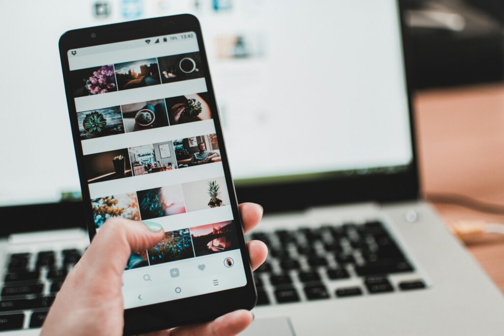 Seorang individu memegang ponsel yang menampilkan beberapa foto, dengan latar belakang sebuah laptop komputer. Platform media sosial seperti YouTube menyediakan ruang bagi penggunanya untuk berbagi beragam jenis konten, baik itu foto-foto yang terlihat di ponsel maupun video-video populer yang sering ditemukan di YouTube. Jika Anda membutuhkan penyesuaian lebih lanjut atau pengubahan lainnya, beri tahu saya!