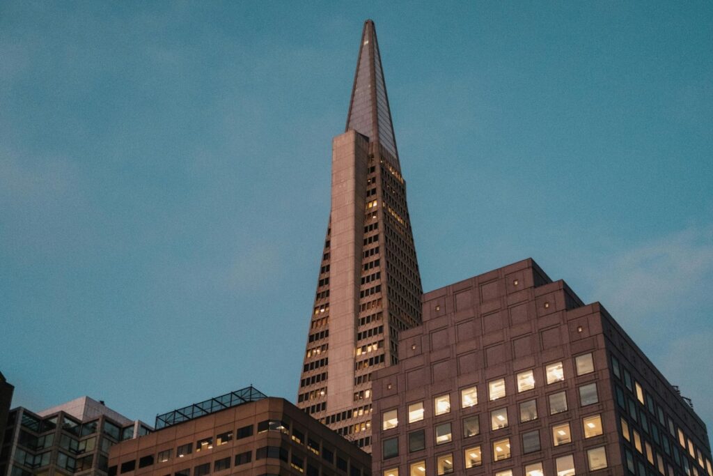 Una torre triangular de edificios de altas horas con luces interiores encendidas. Los bloggers de Insta pueden buscar inspiración en estos ambientes urbanos mientras aprenden cómo obtener anuncios US y monetizar sus perfiles.