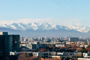 这幅图展现了智利城市错落的建筑群与远处巍峨的雪山景观。城市与自然相互映衬，尽显独特魅力。就如同在2025年智利社交媒体营销趋势中，品牌主与网红也需掌握最新玩法，让营销与社交潮流相互融合，在这片充满活力的土地上绽放光彩 。