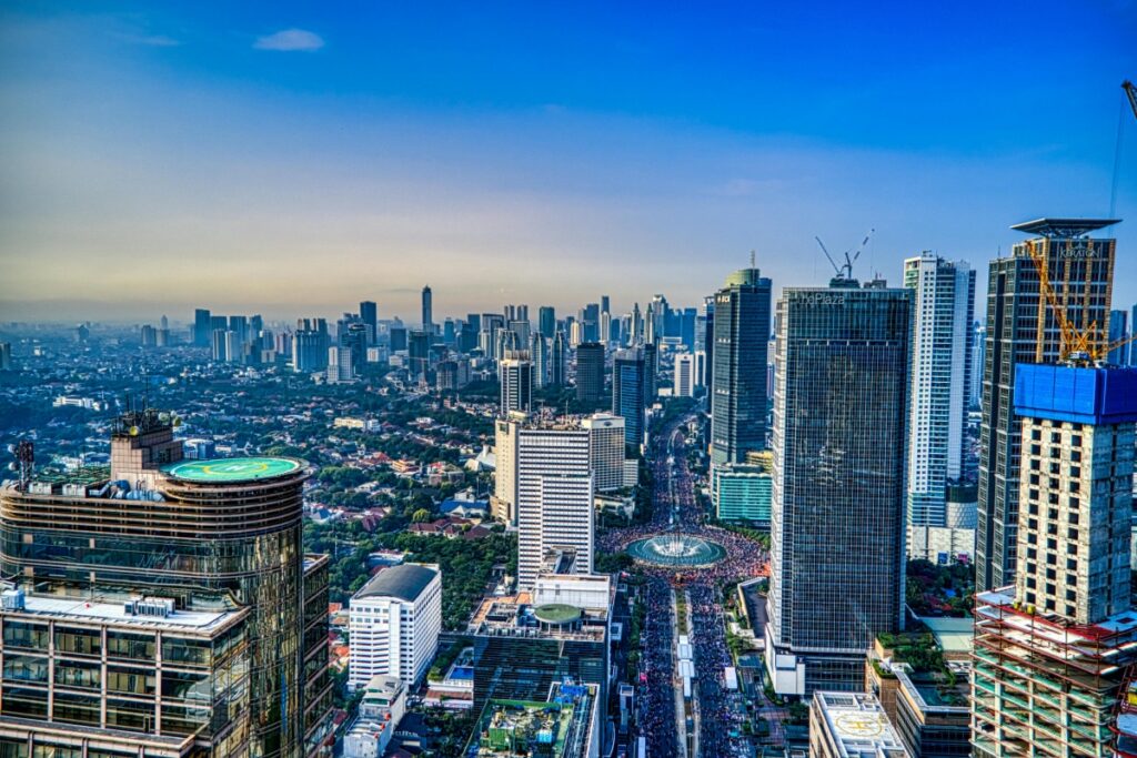 Gambar ini menunjukkan pemandangan megapolitan sebuah kota, kemungkinan Jakarta. Anda akan melihat bangunan - bangunan tinggi modern yang membentuk langit - langit kota. Di tengahnya, ada jalan raya yang ramai dengan kendaraan dan di beberapa tempat, proyek pembangunan sedang berlangsung. Mengenai digital marketing, "Bagaimana Menggunakan KWAI untuk Pemasaran di Indonesia" menjadi topik penting. KWAI dapat menjadi sarana hebat untuk mencapai audiens luas di kota - kota besar seperti yang terlihat di gambar ini, dengan cara yang kreatif dan efektif.