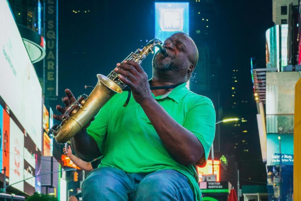 Một nghệ sĩ saxophone đường phố biểu diễn đầy đam mê trên đường phố nhộn nhịp về đêm, ánh sáng neon phản chiếu trên cây kèn đồng của anh. Khoảnh khắc đầy cảm xúc, thể hiện sức mạnh của âm nhạc trong việc kết nối con người. BaoLiba – Ngôi Nhà Của Micro Influencer Trên Toàn Cầu.