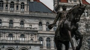 A bronze statue of a man on horseback stands prominently in front of an ornate, historic building with arched windows and detailed stonework. The imposing structure and the dignified statue together create a sense of grandeur and history. Just as this timeless scene marks a moment frozen in time, the announcement "Goodbye! Skype Officially Shuts Down on May 5, 2025" signals the end of an era in digital communication, marking a shift and the need to adapt to new technological landscapes.
