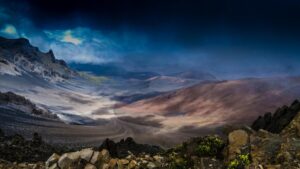 A stunning view of a rugged mountainous landscape under a dramatic sky. The terrain showcases a mix of rocky outcrops and earthy slopes, bathed in a play of light and shadow. For those interested in unique content creation, this scene might inspire ideas, much like exploring "How to Make Money on Tinder (U.S. Version for Creators, Hustlers, and Digital Side - Hustlers)" could open new revenue streams in the digital space.