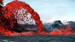 A dramatic scene of molten lava erupting, creating an arching spray of bright red against a muted, smoky landscape. Just as this natural phenomenon commands attention, understanding "How to Use ShareChat for Business Marketing in India (for U.S.-Based Brands & Advertisers)" can open up powerful avenues for brands to capture the interest of Indian audiences.