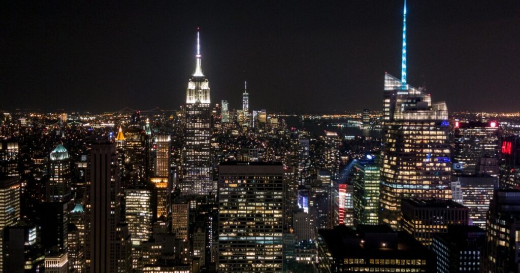 A night - view of the bustling New York City skyline with numerous skyscrapers lit up. Among them, the iconic Empire State Building stands out. Amidst the city's glow, one might wonder: Why Did Facebook Kill Lasso App?