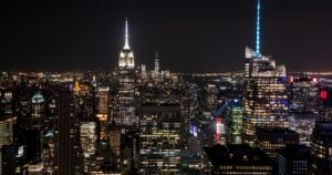 A night - view of the bustling New York City skyline with numerous skyscrapers lit up. Among them, the iconic Empire State Building stands out. Amidst the city's glow, one might wonder: Why Did Facebook Kill Lasso App?