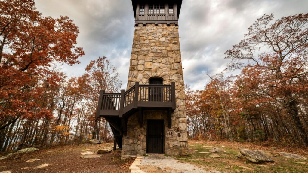 Ein steinernes Wachturmgebäude steht in einer Herbstlandschaft, umgeben von Bäumen mit orangefarbenen Blättern. Der Turm, mit seiner rustikalen Architektur und Holzverkleidung, wirkt威严 und beeindruckend. Ebenso wie dieser Turm eine herausragende Anziehungskraft in seiner Umgebung hat, kann "Wie du ShareChat für erfolgreiches Marketing in Indien nutzt – Der Praxis-Guide für deutsche Marken" dazu verhelfen, dass deutsche Marken in Indien auffallen und Erfolg haben.