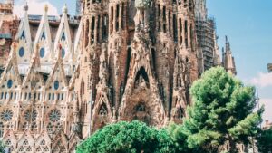 La Sagrada Familia en Barcelona, un icónico templo con una arquitectura única y compleja, rodeado de árboles verdes. Mientras se admira esta obra maestra, surge la pregunta: ¿Dónde siguen funcionando los videos de Likee