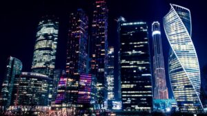 Ночная панорама города с высокими небоскребами, которые иллюминированы разноцветными светами. Среди этого мрака и яркости возникает вопрос: В каких странах видео из Likee до сих пор смотрят