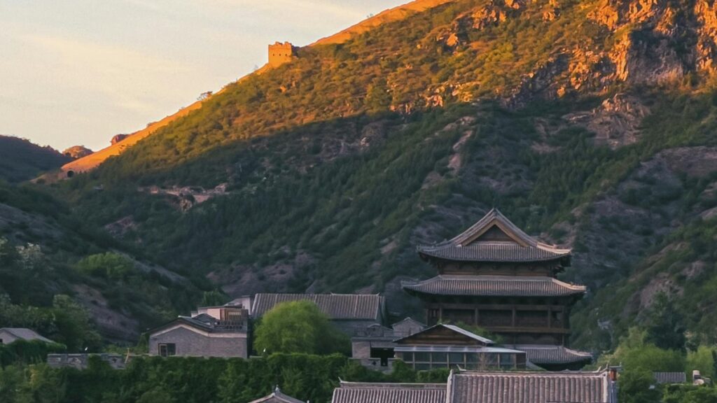 夕阳余晖洒在山峦上，古老的长城蜿蜒其间，山脚下中式传统建筑错落有致。同时，了解通讯知识：什么是 iMessage，它和短信 SMS 到底有啥不一样？