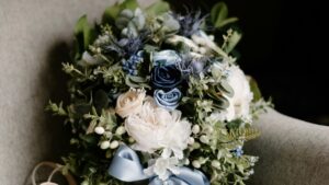 A beautifully arranged bouquet with white and blue flowers and green foliage, placed on a textured surface. This floral arrangement is related to the 2025 Charging Standards for Funimate Influencer Promotions in China, symbolizing elegance and charm in promotional contexts.