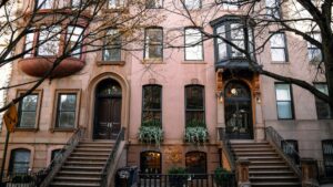 A charming row of historic brownstone buildings in the U.S., featuring ornate architectural details, elegant bay windows, and inviting entrances flanked by steps. This picturesque urban scene is associated with the 2025 Charging Standards for LinkedIn Influencer Promotions in the U.S., highlighting the aesthetic backdrop relevant to influencer marketing initiatives.