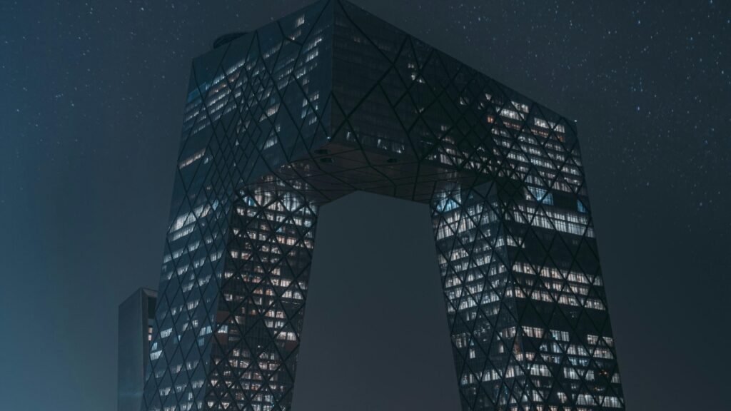 这是一张展示现代建筑夜景的照片，画面中一座设计独特的摩天大楼在夜空中显得格外引人注目。这座建筑以其不规则的几何形状和网格状的外立面在众多高楼中脱颖而出，其内部灯光透过玻璃幕墙，与繁星点点的夜空交相辉映，营造出一种未来感和科技感。 关于2025年中国Likee网红推广合作收费标准，这将根据网红的粉丝数量、影响力、内容创作能力以及推广活动的具体需求来确定。合作模式可能包括固定费用、按效果付费或两者的结合。具体的收费标准需要与Likee平台或相关网红进行详细沟通，以确保双方对合作条款有清晰的理解和共识。通过与网红的合作，品牌可以更有效地扩大其在目标受众中的影响力，提升品牌知名度和产品销量。