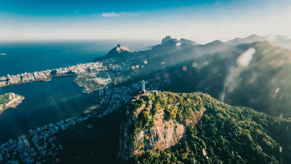 Esta imagem apresenta uma vista panorâmica impressionante de São Paulo, com a estátua do Cristo Redentor em destaque sobre a paisagem. As montanhas e o mar ao fundo tornam a cena ainda mais espetacular. Se você está interessado em descobrir como ganhar dinheiro no Twitter, confira o "Como Ganhar Dinheiro no Twitter Guia Prático para Brasileiros".