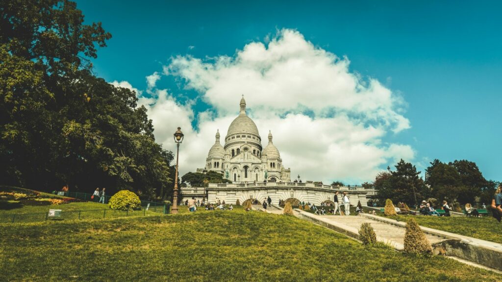 Une vue imprenable du Sacré - Cœur, majestueux édifice religieux à Paris, ensoleillé sous un ciel bleu avec des nuages. Cette image est également associée aux Pricing Standards for Influencer Promotions on Telegram in the US for 2025.
