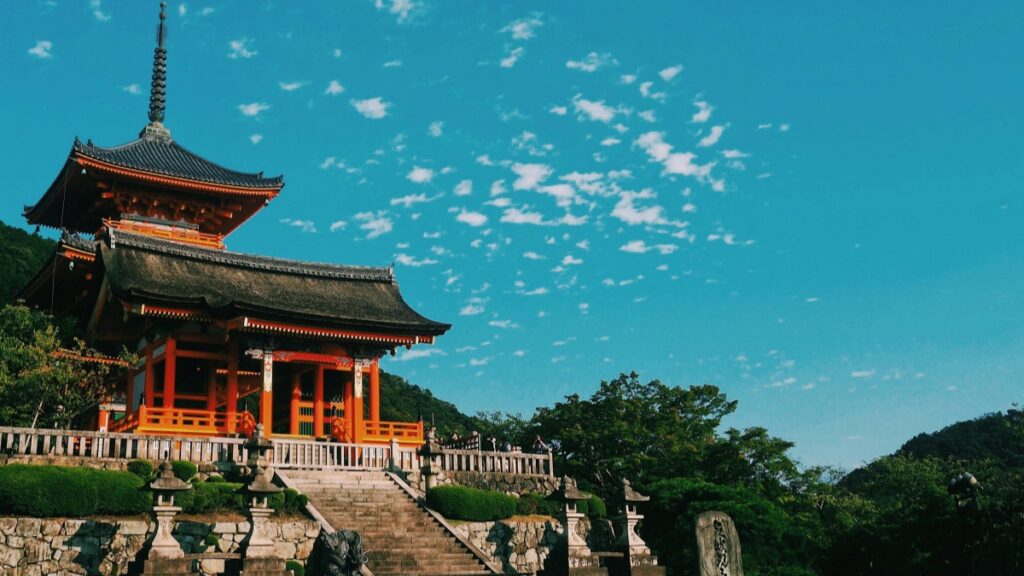 2025年の日本でREDnoteインフルエンサーとの推進協力料金基準に関する背景で、この美しい寺院は日本の伝統的な建築様式を備え、鮮やかな朱色の梁や柱が目を引き、青空と緑豊かな自然と共に、神秘的で荘厳な雰囲気を醸し出しています。